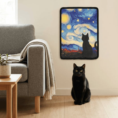 A black cat sits on a light wood floor in a living room setting, looking at a wall-mounted pet cat tree topper featuring a Van Gogh-inspired starry night sky design with a black cat silhouette.